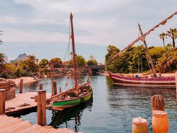 Boats moored in river against sky