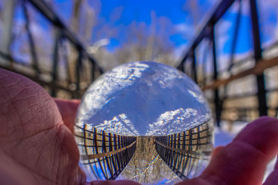 Close-up of man holding umbrella against sky