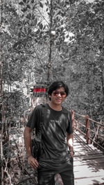Portrait of smiling boy standing against trees