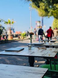 Close-up of people on table by street against sky