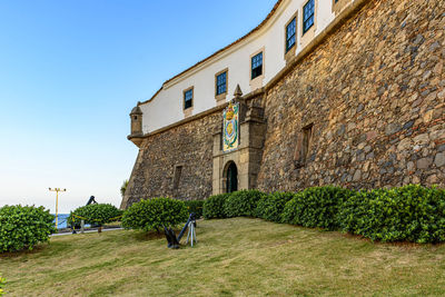 Facade of the old and historic fort and barra lighthouse at afternoon in the city of salvador, bahia