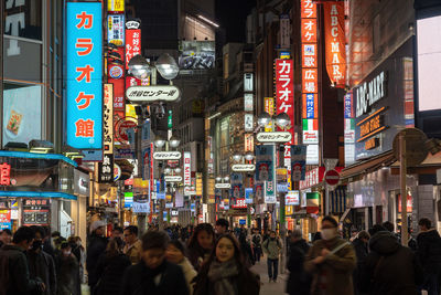 People walking on city street at night