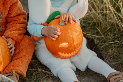 High angle view of woman holding pumpkin on field