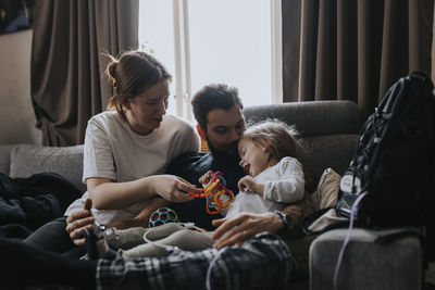 Parents playing with disabled child on sofa