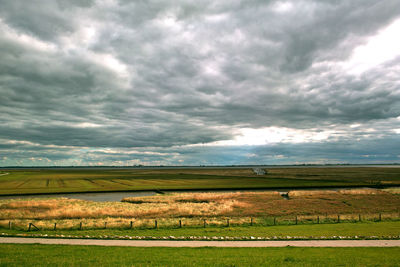 Scenic view of landscape against cloudy sky