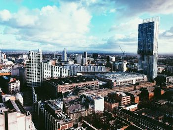 Aerial view of cityscape against cloudy sky