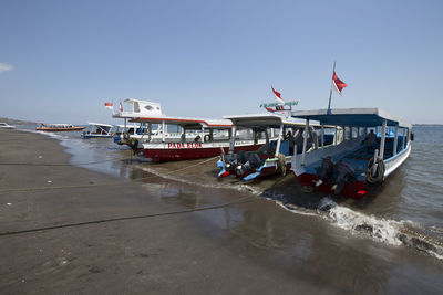 View of boats on beach against clear sky