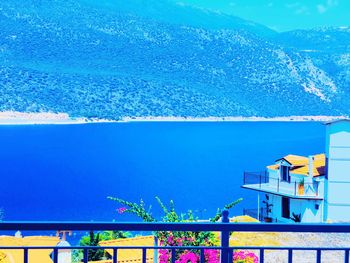 Scenic view of swimming pool by sea against blue sky