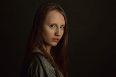 Portrait of beautiful woman against black background