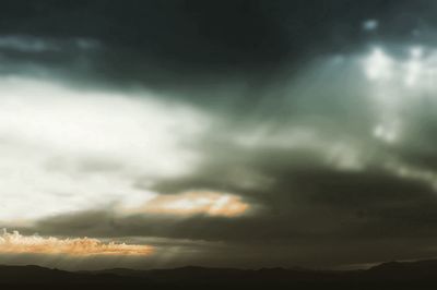 Low angle view of storm clouds at sunset