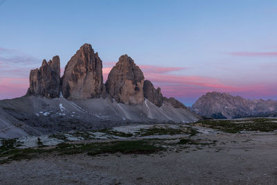 Rock formations on landscape against sky during sunset