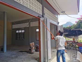 Rear view of man standing by building