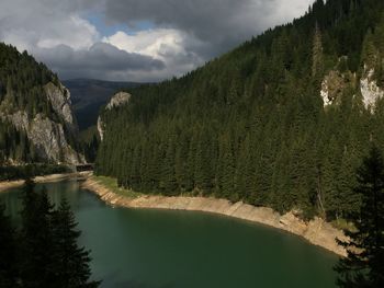 Scenic view of lake by mountains against sky