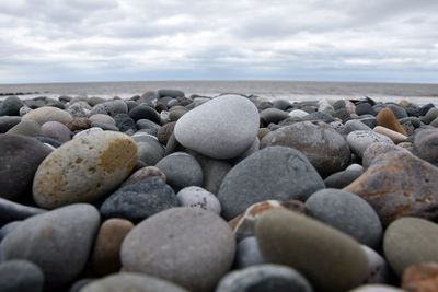 Stones on beach against sky