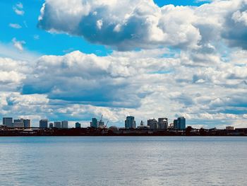 View of buildings in city against cloudy sky