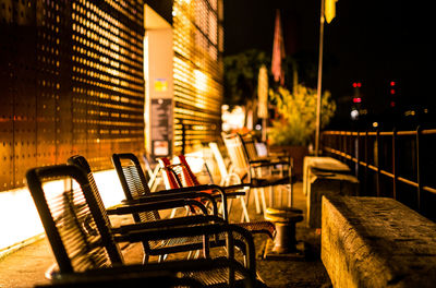 Empty chairs in city at night