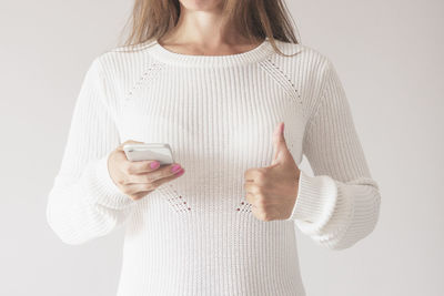 Midsection of woman standing against white background