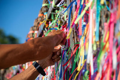 Severed hand of a person holding souvenir ribbons