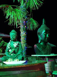 Statue against temple at night