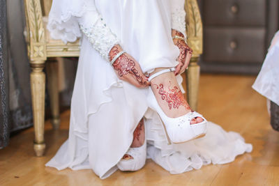 Midsection of mother and daughter on floor