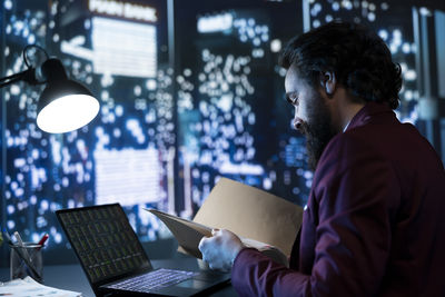 Side view of man using digital tablet in office