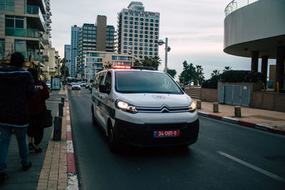 Rear view of vehicles on city street by buildings