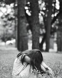 Sad woman sitting on field