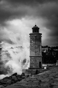 Lighthouse by sea against sky