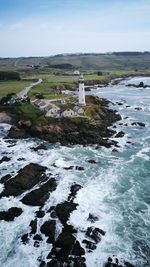 Lighthouse by sea against sky