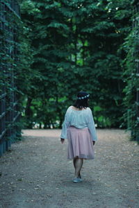 Rear view of woman walking on footpath