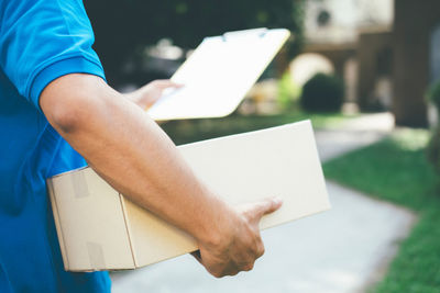 Cropped image of delivery man holding box