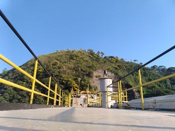 Road by building against clear blue sky