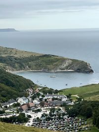 High angle view of townscape by sea against sky