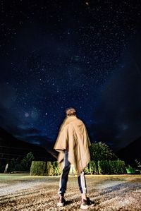 Full length of man standing against star field at night