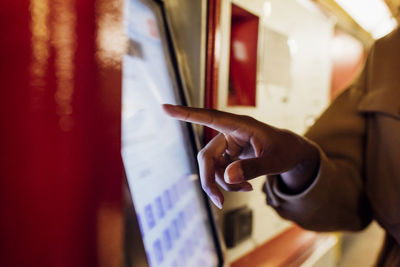 Woman using ticket machine at subway station
