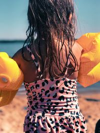 Midsection of woman standing at beach