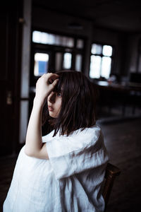 Beautiful woman looking away while sitting at home