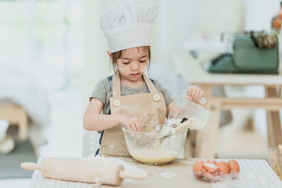 Portrait of cute boy having food in kitchen at home