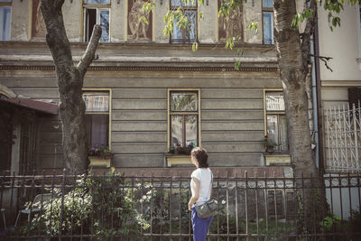 Rear view of man standing against tree