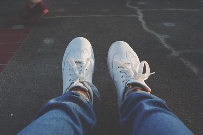 Low section of man wearing shoes on road