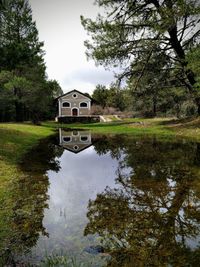 Reflection of building on lake against sky