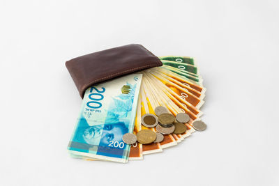 High angle view of paper currency in wallet with coins on gray background