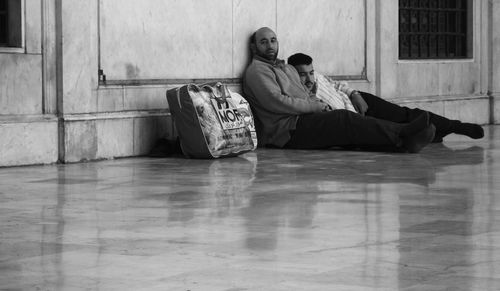 Rear view of couple sitting on floor