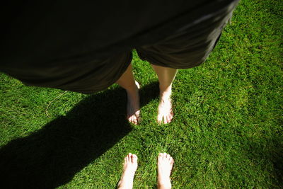 Low section of man standing on grassy field