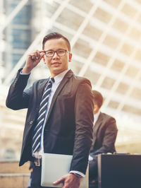 Low angle view of businessman against office building