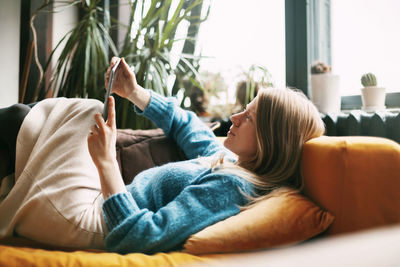 Side view of senior woman resting on sofa at home