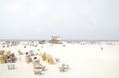 Panoramic view of people on beach against sky