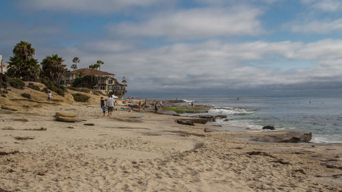 People on beach against sky