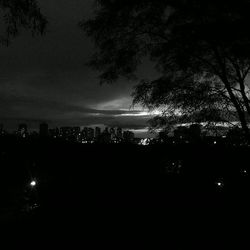 Silhouette of buildings against sky at night