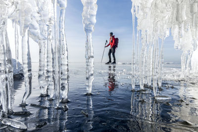 Person ice skating, icicles on foreground, sweden